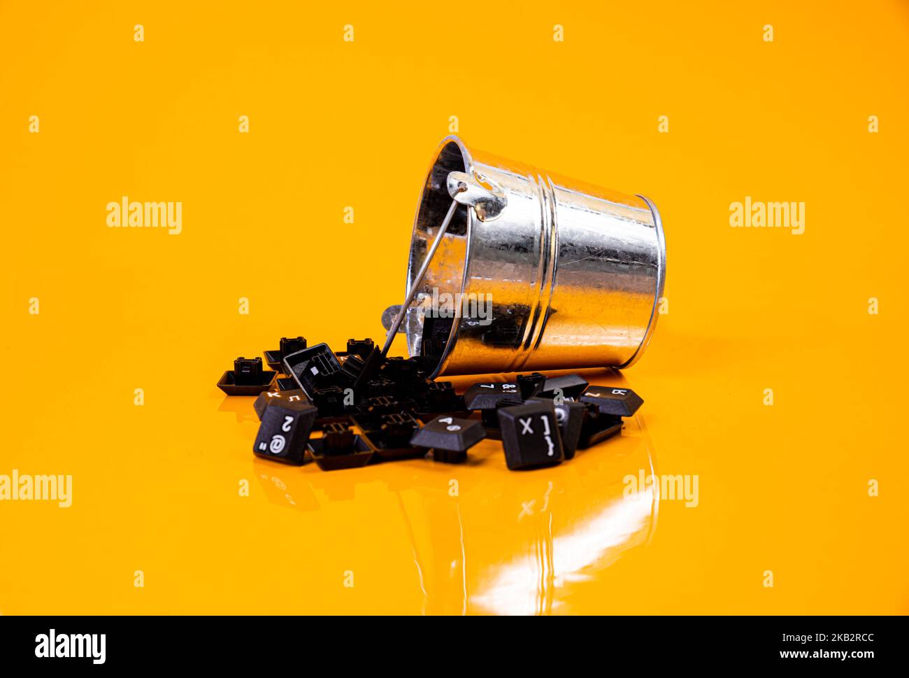 Tastatur-Taste in Glas in Eimer auf orangefarbenem Hintergrund isoliert Hacker Stockfoto