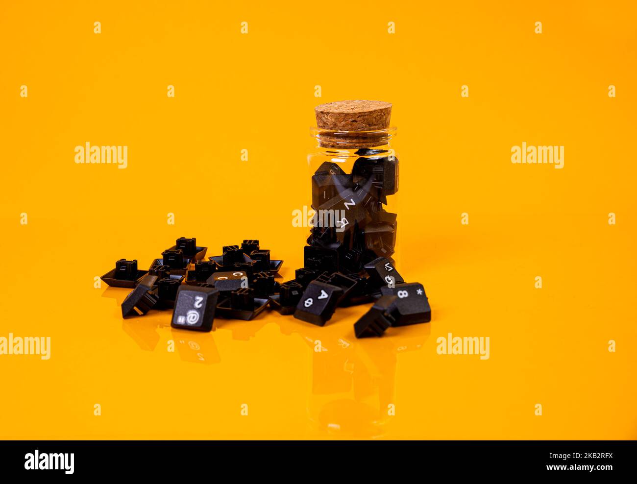 Tastatur-Taste in Glas in Eimer auf orangefarbenem Hintergrund isoliert Hacker Stockfoto