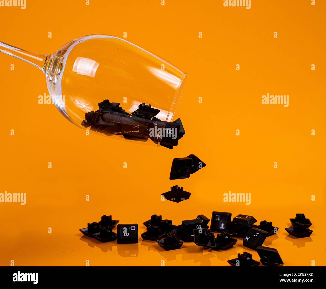 Tastatur-Taste in Glas in Eimer auf orangefarbenem Hintergrund isoliert Hacker Stockfoto
