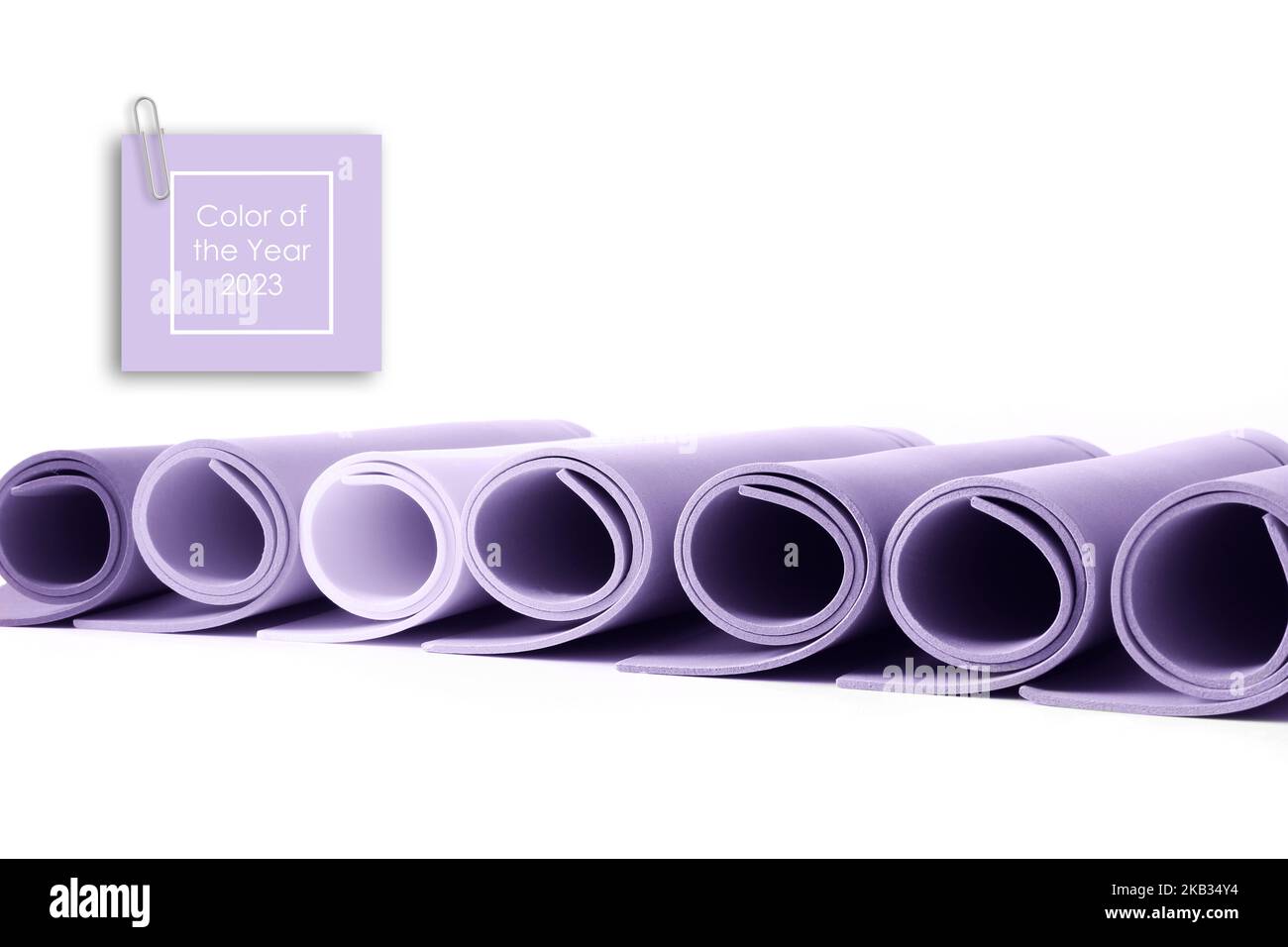 Papierrollen in Lavendelfarbe auf weißem Hintergrund getönt. Konzept der trendigen digitalen Lavendel Farbe. Textfarbe des Jahres 2023 Stockfoto