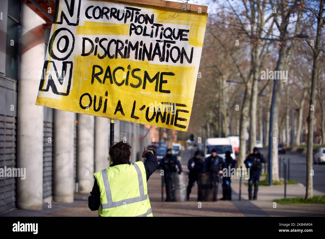 Ein Mann aus der Gelbweste zeigt Polizisten, die ein Plakat mit der Aufschrift „Nein zu Korruption, zu Diskriminierung, zu Rassismus, Ja, vereint zu sein“ halten. Yellow Vests und eine Theaterkolizei spielten ein Theaterstück über Polizeigewalt und Personen, die während der 10-wöchigen Proteste der Gelbwesten-Bewegung in Frankreich von der Polizei verletzt wurden. Mehrere Dutzend Menschen haben aufgrund des Einsatzes von Flashball (LBD40) und Stichballgranaten ein Auge oder ein Mitglied verloren. Sie wollten das Bewusstsein über die Mittel der Polizei zur Kontrolle von Menschenmengen mit Zeugnissen der Menschenrechtsliga, Anwälten und Demonstranten der Gelbwesten schärfen. Toulouse. Frankreich. Januar 18. Stockfoto