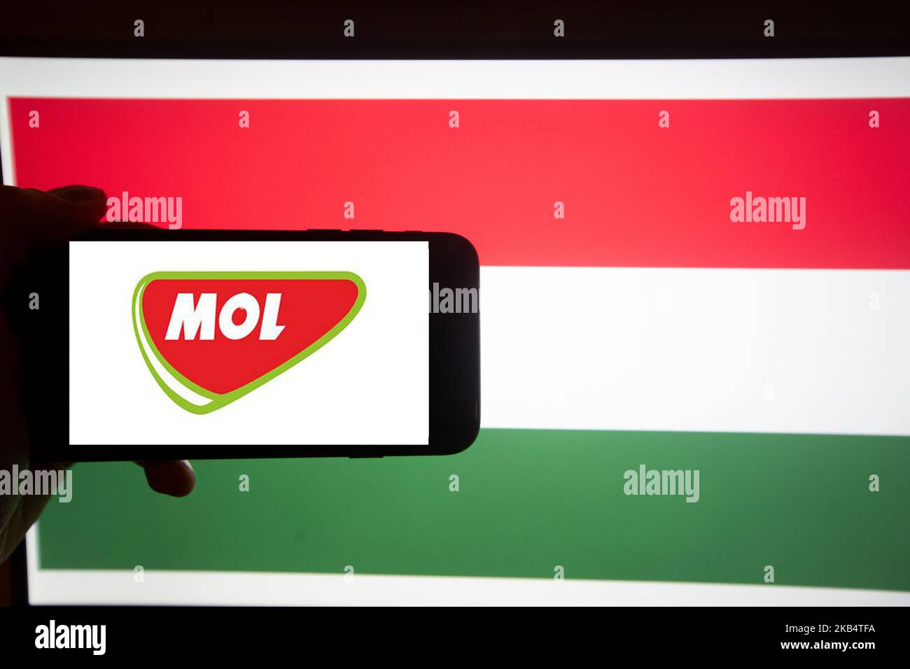 Das Logo der MOL Group ( Magyar Olaj- és Gázipari Részvénytársaság, ungarische Öl- und Gasgesellschaft) ist auf einem Bildschirm eines Smartphones vor einer ungarischen Flagge zu sehen. Es ist Teil des BUX, dem wichtigsten Index Ungarns. (Foto von Alexander Pohl/NurPhoto) Stockfoto