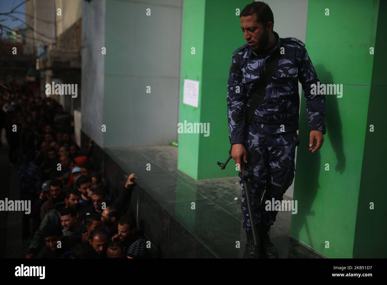 Sicherheitskräfte, die der Hamas treu sind, organisieren am 26. Januar 2019 Menschen, die sich vor dem zentralen Postamt in Gaza-Stadt anstellen, um finanzielle Hilfe von der katarischen Regierung für verarmte palästinensische Familien zu erhalten. (Foto von Majdi Fathi/NurPhoto) Stockfoto