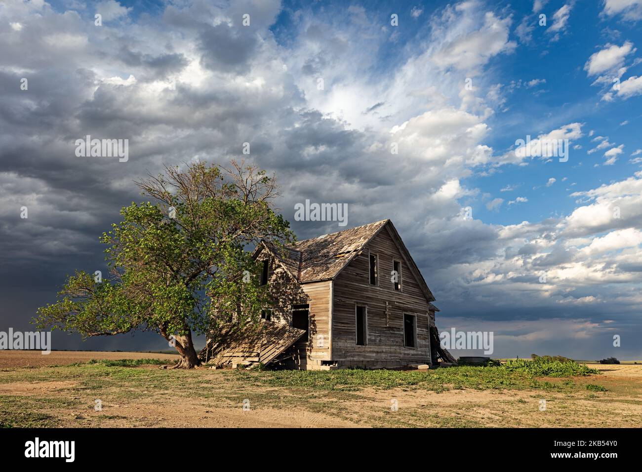 Ein altes, verlassenes Haus mit dunklen Sturmwolken im ländlichen Nebraska Stockfoto