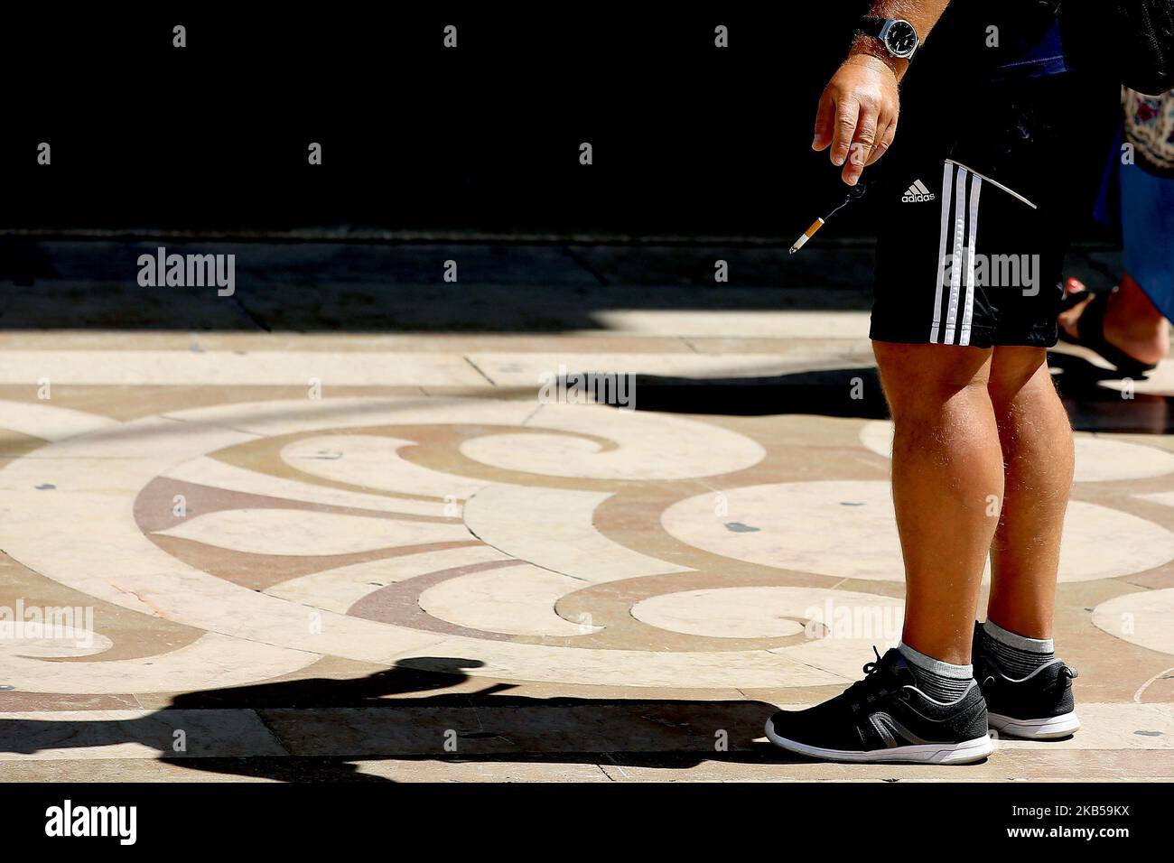Am 4. September 2019 wirft ein Rauchner in Lissabon, Portugal, eine Zigarette zu Boden. Das Gesetz, das Maßnahmen zur Sammlung und Behandlung von Tabakabfällen genehmigt und mit Geldstrafen zwischen 25 und 250 Euro bestraft, die Hinterteile auf die öffentliche Straße werfen, wurde am 3. September in Republic Diary veröffentlicht. Zigarettenkippen, Zigarren oder andere Zigaretten, die Tabakprodukte enthalten, werden ab heute als fester Stadtabfall assimiliert, und ihre Entsorgung im öffentlichen Raum ist daher verboten. (Foto von Pedro FiÃºza/NurPhoto) Stockfoto