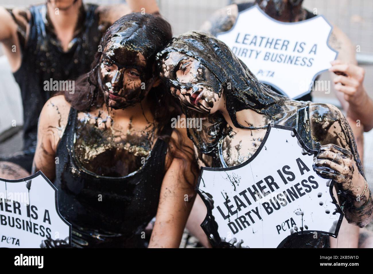 PETA-Aktivisten geben sich am 13. September 2019 vor dem Hauptveranstaltungsort der London Fashion Week am Strand in London, England, schwarzen „toxischen Schleim“, um das Thema gefährlicher Abfälle im Zusammenhang mit der Lederindustrie zu beleuchten. PETA fordert die London Fashion Week auf, Tiere und die Umwelt durch ein Verbot der Verwendung von Leder zu schützen. (Foto von Wiktor Szymanowicz/NurPhoto) Stockfoto