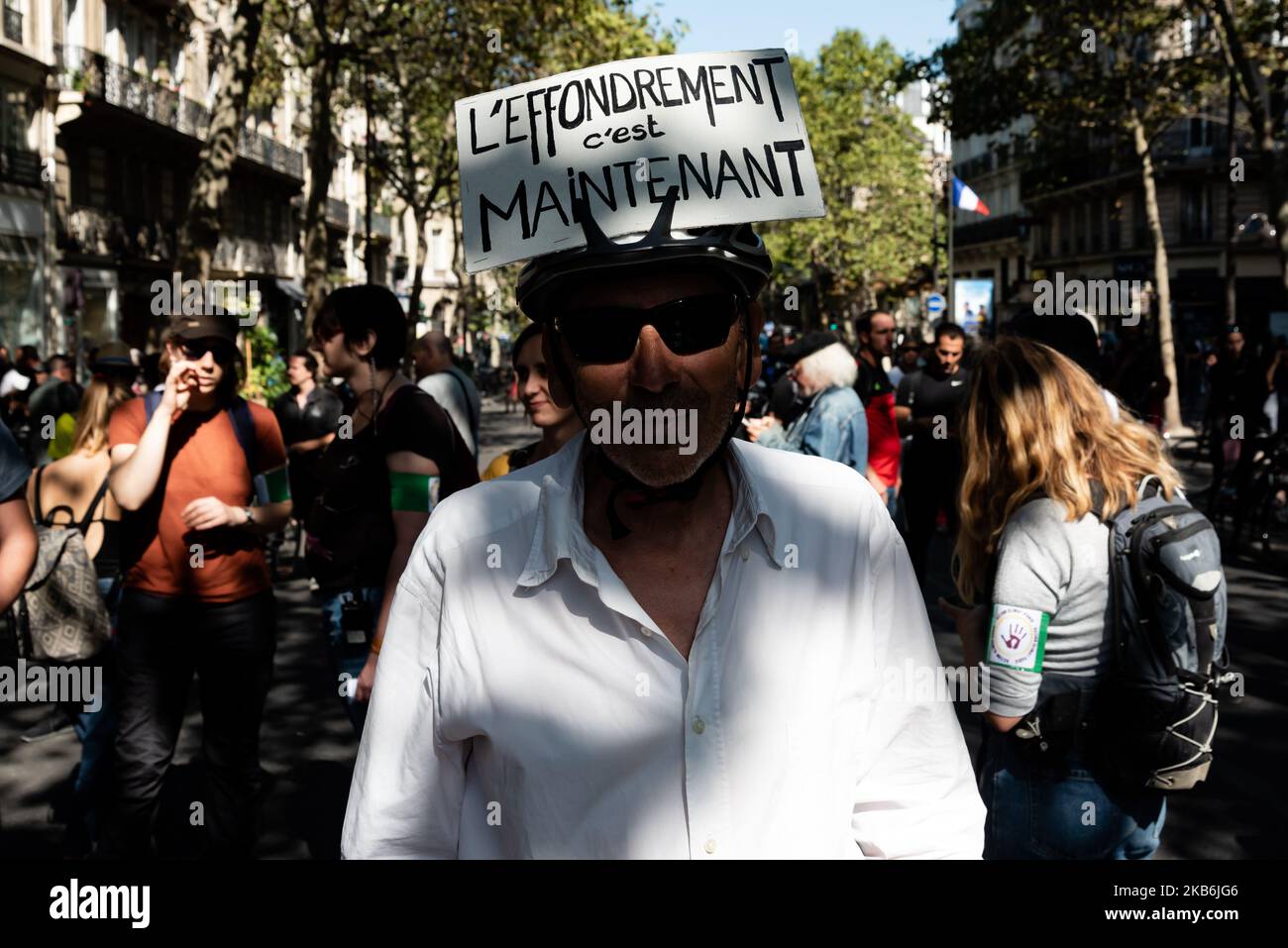 Ein Demonstrator posiert mit einem auf dem Kopf befestigten Schild, auf dem steht: „Der Zusammenbruch ist jetzt“, an diesem Samstag, dem 21. September 2019, für den 45. Akt der Gilets Jaunes, der einen großen Tag der nationalen Mobilisierung in Paris mit dem Wunsch organisierte, die Champs-Elysées zurückzugewinnen. Nachdem sie den ganzen Morgen vergeblich versucht hatten, sich im Zentrum von Paris zu versammeln, jedes Mal von der Polizei zerstreut, schlossen sich die Gelbwesten und der Schwarze Block dem von Umweltorganisationen organisierten klimamarsch an. Schnell brachen auf dem Weg der Prozession bis spät in die Nacht Zusammenstöße zwischen dem Schwarzen Block und der Polizei aus. (P Stockfoto