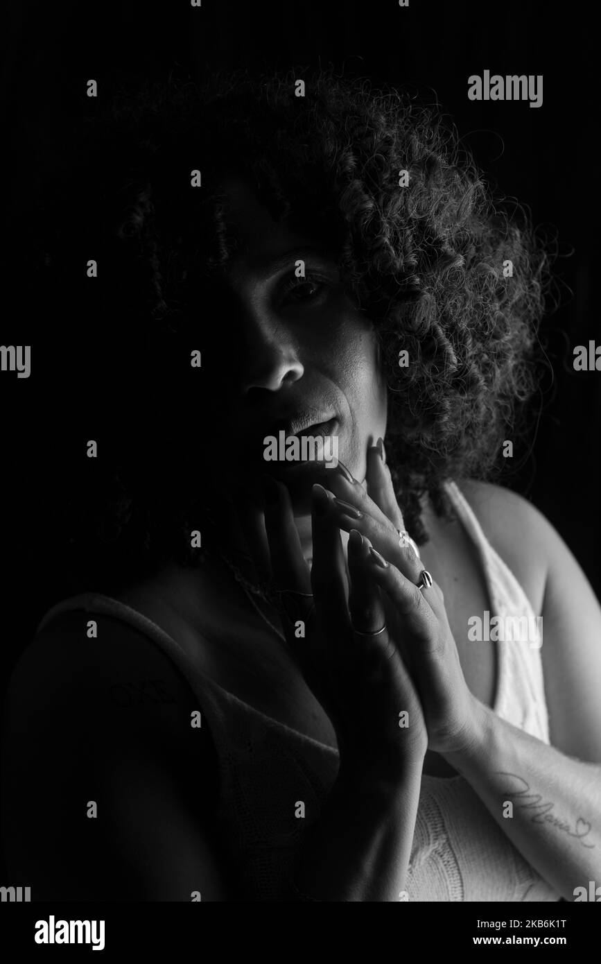 Nahaufnahme eines Schwarz-Weiß-Porträts einer Frau mit den Händen im Gesicht. Glückliche Frau. Salvador, Brasilien. Stockfoto
