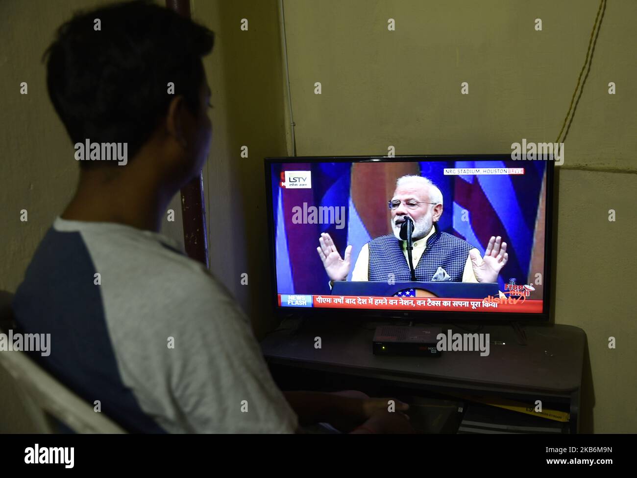 Ein Mann, der die Live-Übertragung von Premierminister Narendra Modi im Fernsehen sieht, spricht am 22. September 2019 in Guwahati, Assam, Indien, ‘einer riesigen Gala „Howdy, Modi“. (Foto von David Talukdar/NurPhoto) Stockfoto