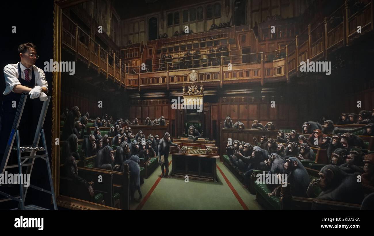 Die Arbeiter der Galerie posieren mit dem Banksy-Gemälde „Devolved Parliament“ bei Sotheby's am 27. September 2019 in London, England. Fotoanruf für Banksy's devolved Parliament painting, bevor es auf einer Auktion von Sotheby's angeboten wird. Das Kunstwerk, das das Unterhaus voller Schimpansen zeigt, wird voraussichtlich GBP1,5 bis GBP2 Millionen erreichen. (Foto von Giannis Alexopoulos/NurPhoto) Stockfoto