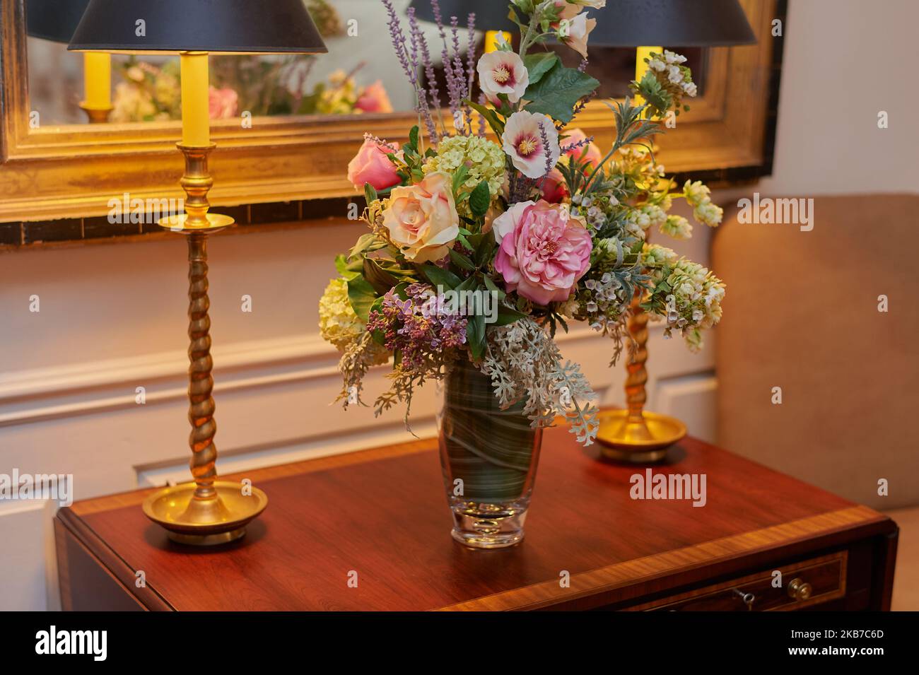 Blumenstrauß auf einem Tisch mit zwei schattigen Lampen Stockfoto