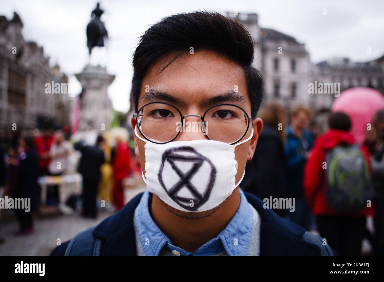 Ein Mitglied der klimaaktivistischen Bewegung Extinction Rebellion (XR), das eine Gesichtsmaske mit dem Sanduhrlogo der Gruppe trägt, posiert am vierten Tag der zweiwöchigen "Internationalen Rebellion" der Gruppe in London, England, am 10. Oktober 2019 für ein Bild auf dem Trafalgar Square. Bis zum Mittag des Donnerstags hatte die Polizei die Demonstrationen auf dem Trafalgar Square und den Straßen um den Trafalgar Square, wo eine beträchtliche Anzahl von XR-Anhängern blieb, fast eingedämmt. Ein Leichenwagen mit einem Sarg für "unsere Zukunft", der seit Montag am Ausgang Whitehall vom Platz geparkt war, wurde am frühen Nachmittag entfernt. (Foto b Stockfoto