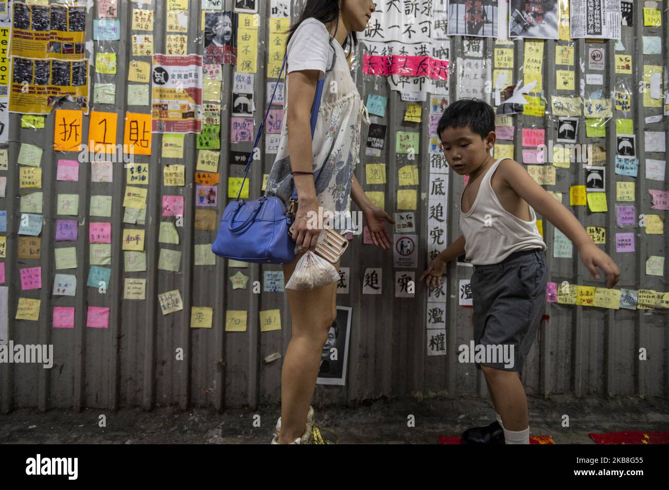 Ein Junge (R) steht neben einer Frau (L) vor einer Lennon-Mauer in Hongkong, China, 17. Oktober 2019. (Foto von Vernon Yuen/NurPhoto) Stockfoto