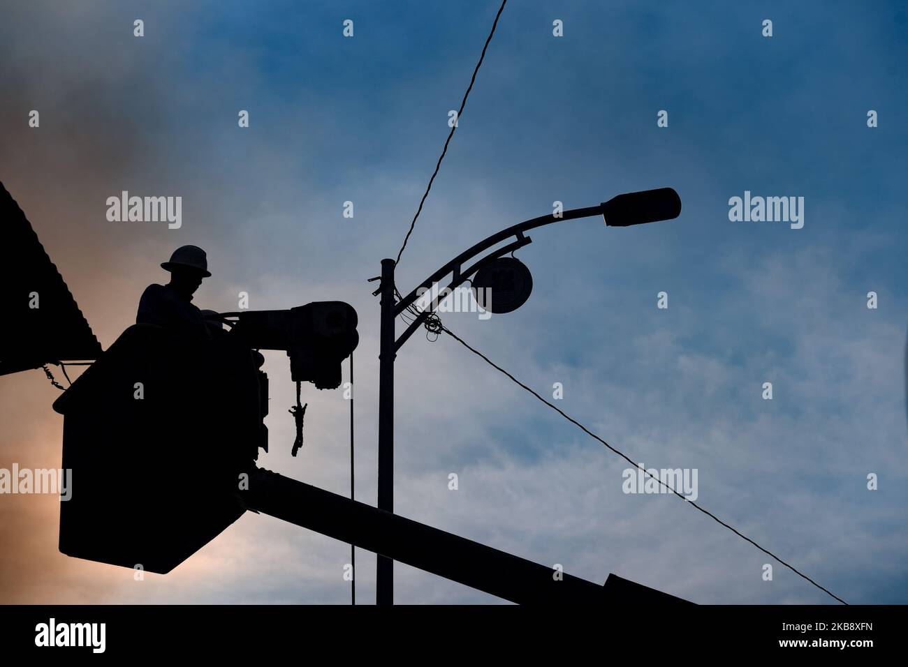 Linemen schnitten elektrische Drähte ab, nachdem ein Feuer ein Wohngebiet neben dem Manila Bureau of Fire Protection Gebäude in Quiricada St. Ecke Rizal Avenue in Sta überschwebete. Cruz Manila am 22. Oktober 2019. Das Feuer, das die Task Force Bravo erreichte, begann um 11:50 Uhr morgens und wurde um 1:36pm Uhr unter Kontrolle gebracht. Obwohl es keine Verletzten gab, wurden die Schäden auf P800.000 geschätzt, die 264 Familien verdrängten. (Foto von George Calvelo/NurPhoto) Stockfoto