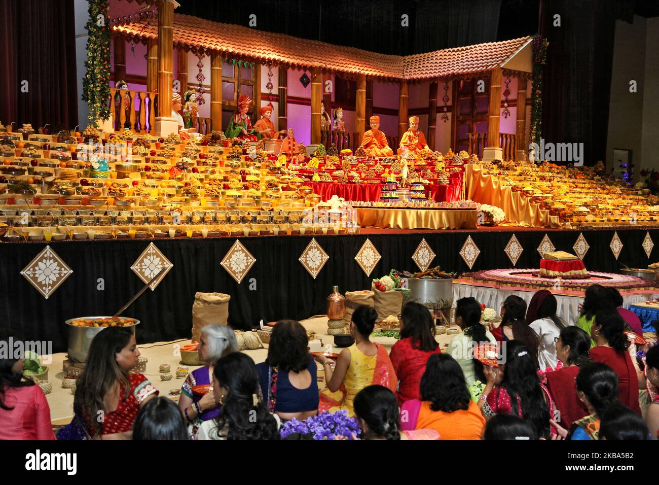 Berge von Süßigkeiten und vegetarischen Snacks werden vor den Gottheiten am BAPS Shri Swaminarayan Tempel während der Annakut Darshan (auch bekannt als Annakut Utsav und Govardhan Puja), die am fünften und letzten Tag des Festivals von Diwali stattfindet, angezeigt, Dies markiert den Beginn des Hindu-Neujahrs in Toronto, Ontario, Kanada am 28. Oktober 2019. Annakut, was einen „großen Berg an Nahrung“ bedeutet, der Gott als Zeichen der Hingabe angeboten wird. BAPS (Bochasanwasi Shri Akshar Purushottam Swaminarayan Sanstha) ist eine Sekte des Hinduismus Diksha Vidhi und ihrer Tempel, obwohl sie vielen Hindu gewidmet ist Stockfoto Berge von Süßigkeiten und vegetarischen Snacks werden vor den Gottheiten am BAPS Shri Swaminarayan Tempel während der Annakut Darshan (auch bekannt als Annakut Utsav und Govardhan Puja), die am fünften und letzten Tag des Festivals von Diwali stattfindet, angezeigt, Dies markiert den Beginn des Hindu-Neujahrs in Toronto, Ontario, Kanada am 28. Oktober 2019. Annakut, was einen „großen Berg an Nahrung“ bedeutet, der Gott als Zeichen der Hingabe angeboten wird. BAPS (Bochasanwasi Shri Akshar Purushottam Swaminarayan Sanstha) ist eine Sekte des Hinduismus Diksha Vidhi und ihrer Tempel, obwohl sie vielen Hindu gewidmet ist Stockfoto