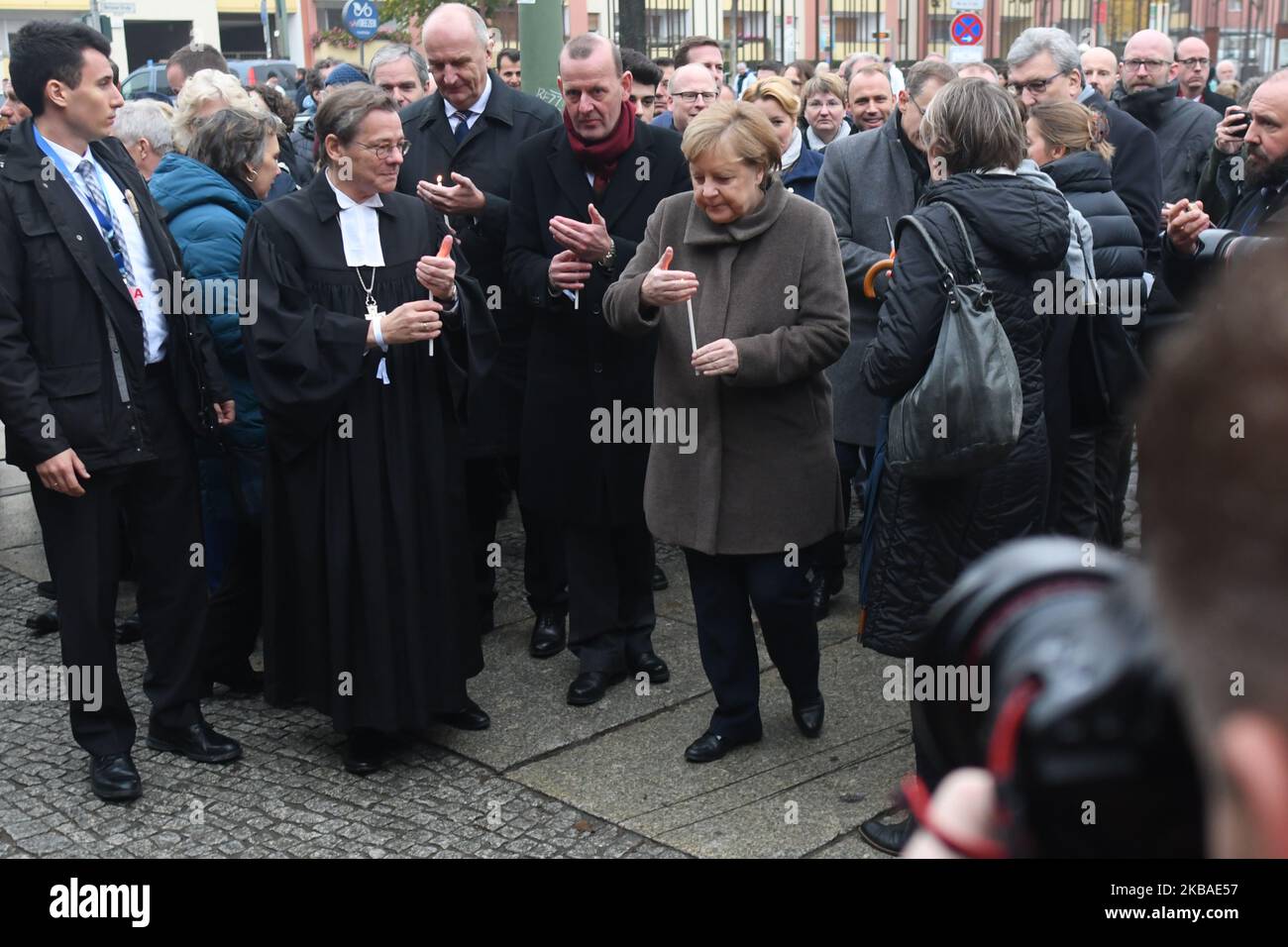 Bundeskanzlerin Angela Merkel (Mitte) und Markus Droege (links), Bischof der Evangelischen Kirche Berlin-Brandenburg-Schlesischen Oberlausitz, kommen mit Kerzen an die Gedenkstätte Berliner Mauer in der Bernauer Straße, um sie anlässlich der Gedenkfeier zum 30.. Jahrestag des Mauerfalls zu platzieren. Am Samstag, den 9. November 2019, in Berlin, Deutschland. (Foto von Artur Widak/NurPhoto) Stockfoto