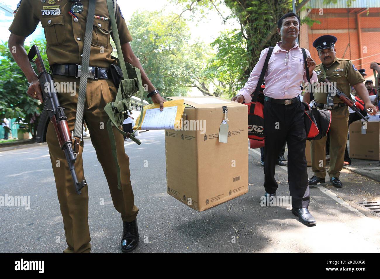 Eine Wahlurne wird von einem srilankischen Polizeibeamten und einem Wahlhelfer vor einem der wichtigsten Verteilungszentren für Wahlmaterial in Colombo, Sri Lanka, getragen. 15. November 2019. Sri Lanka geht am Samstag (16) zur Wahl für eine Präsidentschaftswahl, die ein entscheidender Moment für seine Zukunft sein wird. Das Land ist immer noch von den Bombenanschlägen am Ostersonntag vom 2019. April betroffen, bei denen mehr als 250 Menschen ums Leben kamen, sowie von 18 Monaten politischer Instabilität und Unruhen. (Foto von Tharaka Basnayaka/NurPhoto) Stockfoto