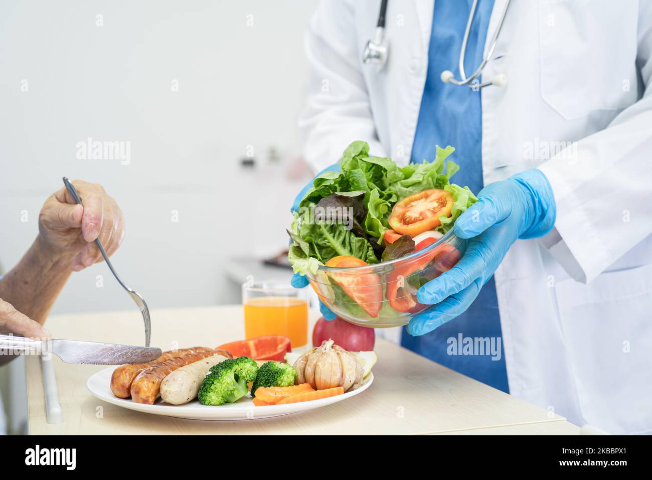 Asiatische ältere oder ältere alte Dame Frau Patientin essen Frühstück und Gemüse gesunde Lebensmittel mit Hoffnung und glücklich, während sitzen und hungrig auf dem Bett in der Zusammenarbeit Stockfoto