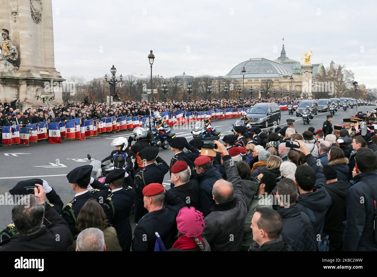 Soldaten und Fahnenträger grüßen, als der Begräbniskonvoi am 2. Dezember 2019 vor dem Invalidendenkmal in Paris die Brücke Alexandre III passiert, bevor 13 französische Soldaten, die am 25. November bei einem Hubschrauberunfall in Mali ums Leben kamen, feierlich geehrt werden. Während einer Mission gegen Extremisten, die der Gruppe des Islamischen Staates angehören. (Foto von Michel Stoupak/NurPhoto) Stockfoto