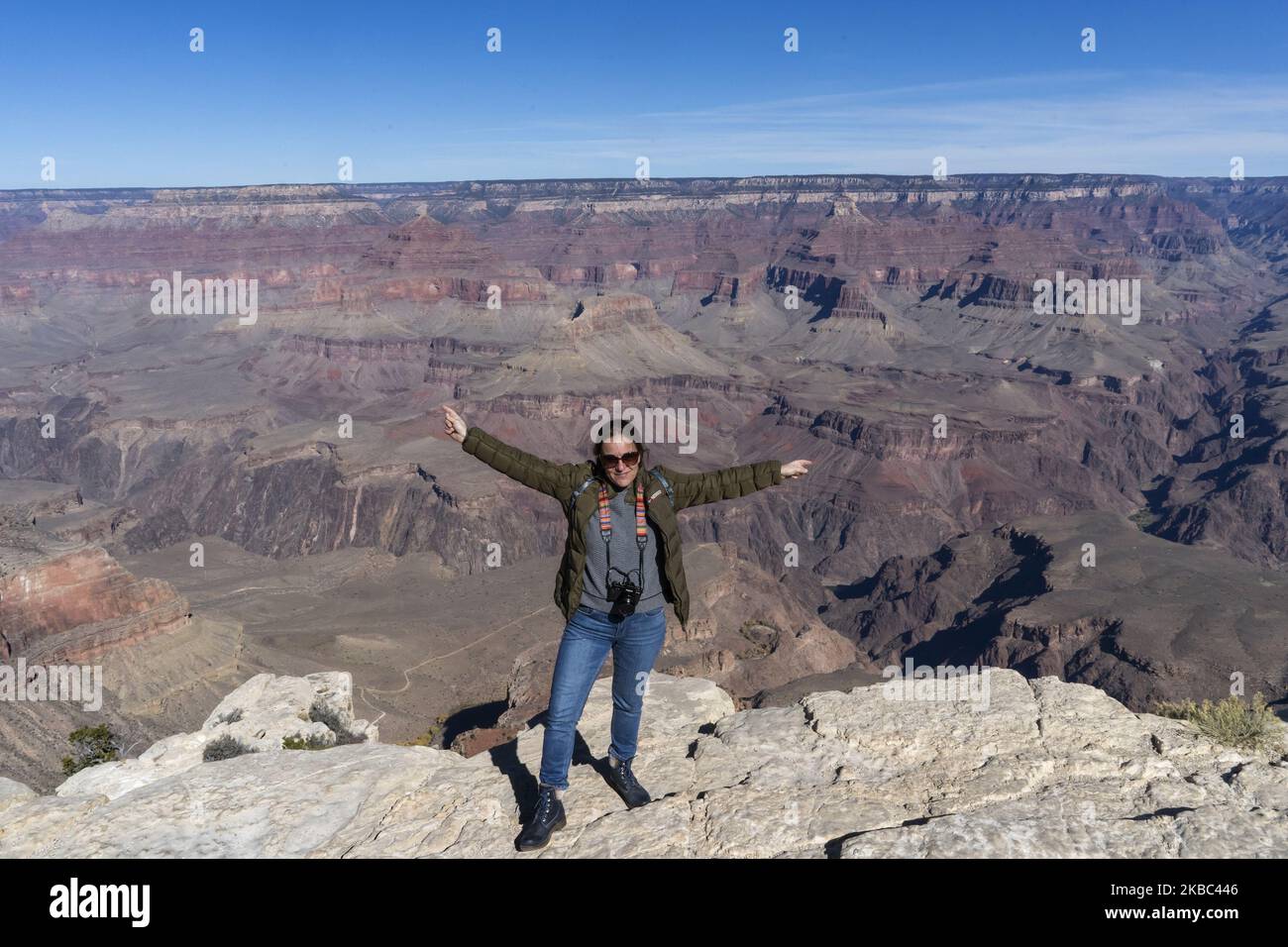 Eine junge Frau wird mit der Landschaft des Grand Canyon of the Colorado (U.S.A) im Hintergrund fotografiert Reisen entlang der historischen Route 66 in Arizona wird zu einer Suche nach „typischen“ Ecken, die an die Atmosphäre erinnern, die sie in den Jahren 50s und 60s des letzten Jahrhunderts hatte, Als es die am häufigsten von Urlaubern genutzte Route war, als die Vereinigten Staaten die Küste Kaliforniens erreichen wollten, wurde diese Route heute nach der Schaffung der Interstate 40 in den Hintergrund gedrängt. Aber wenn Sie von Las Vegas zum Grand Canyon des Colorado fahren, an seinem südlichen Rand, ist es viel mehr Stockfoto