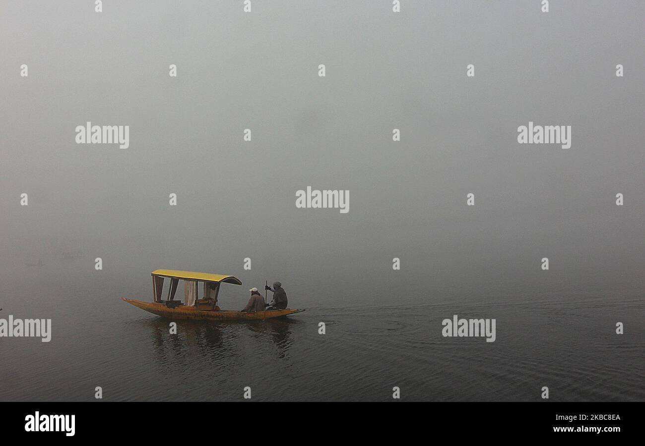 Ein Bootsmann rudert sein Boot an einem nebligen Morgen in Srinagar, Kaschmir, am 06. Dezember 2019. Das Srinagar verzeichnete die kälteste Nacht der Saison bisher bei minus 3,5 Grad Celsius-Gefrierhähnen, Nieten und Wasserkörpern. (Foto von Faisal Khan/NurPhoto) Stockfoto