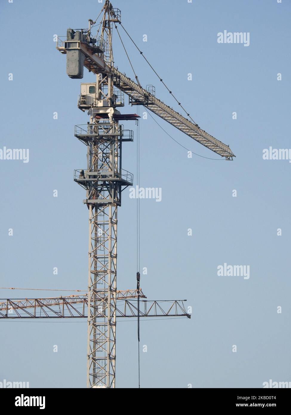 Eine Baustelle mit neuen Wohngebäuden und Hochhäusern mit Kränen zum Transport von schweren Objekten, selektiver Fokus auf Krantürme bei Under Cons Stockfoto