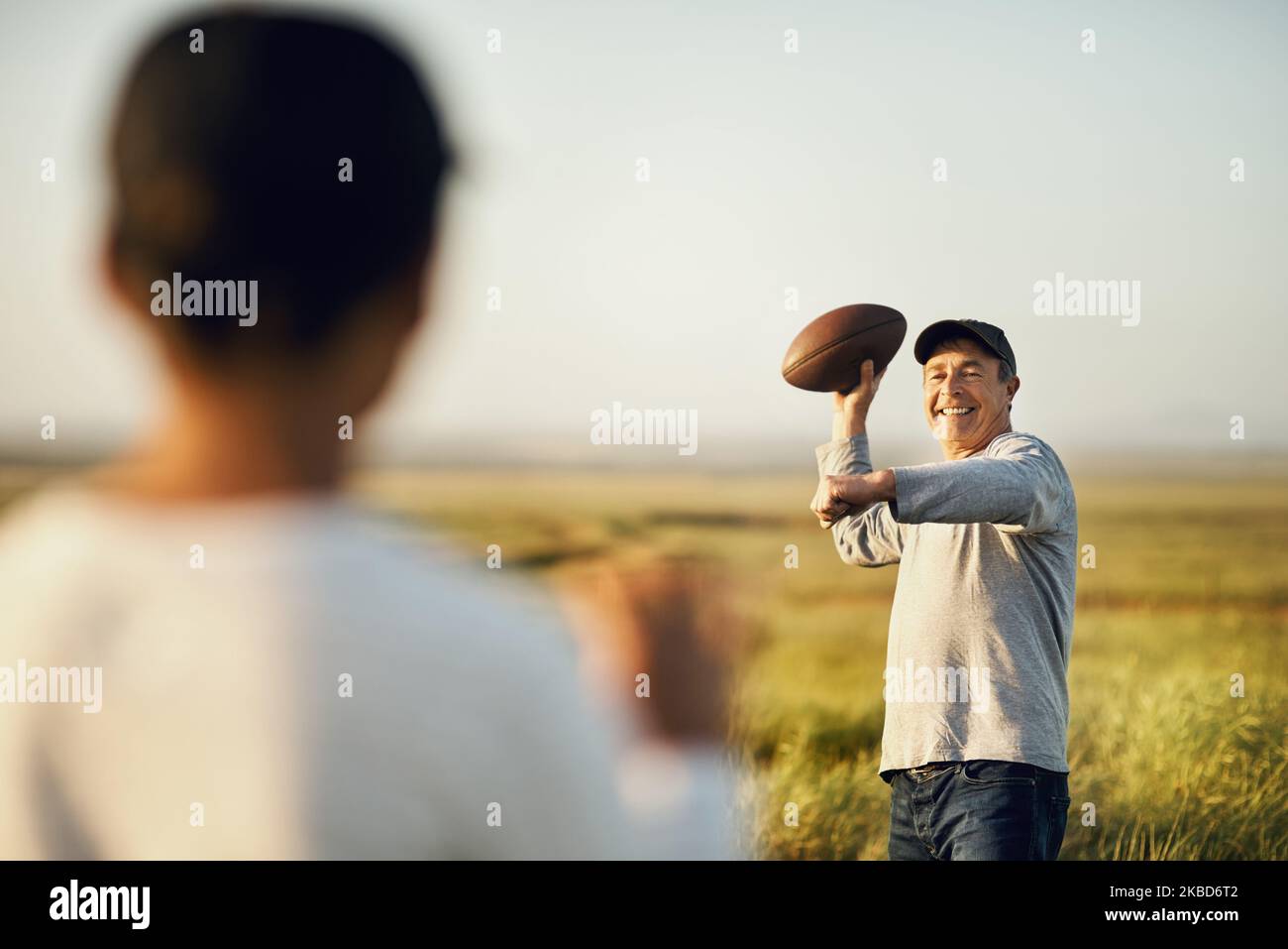Wir lieben das Spiel. Vater und Sohn spielen Fußball auf einem offenen Feld. Stockfoto