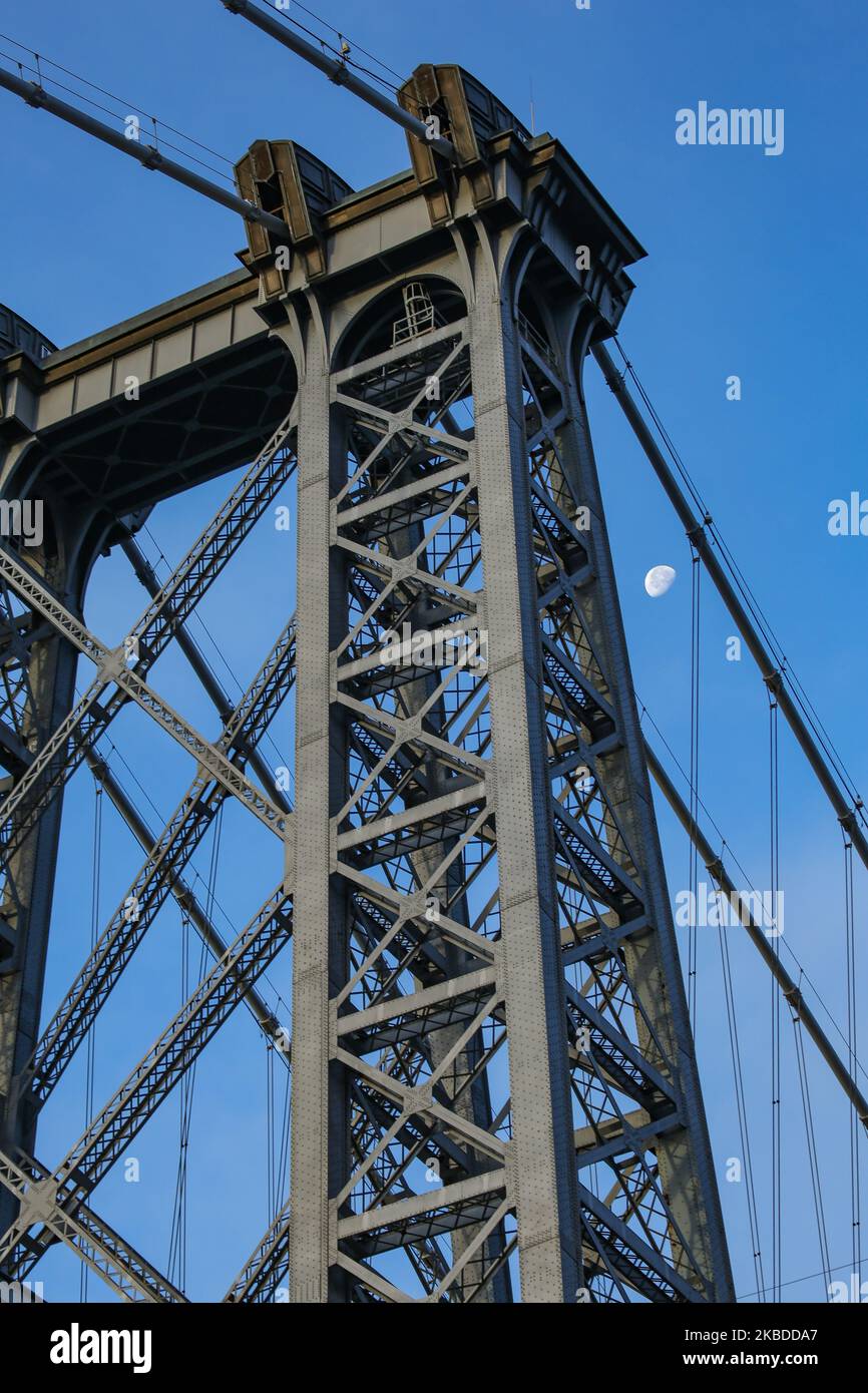 Der Mond durch die Williamsburg Bridge, eine Hängebrücke in New York City über den East River, die Lower East Manhattan mit dem Williamsburg-Viertel in Brooklyn am Broadway verbindet. Die erhellende Luna, der natürliche Erdsatellit im Orbit, wie man sie in der schwindenden Gibbous-Mondkalenderphase mit 76 % Sichtbarmachung sieht. NYC, USA - 17. November 2019 (Foto von Nicolas Economou/NurPhoto) Stockfoto