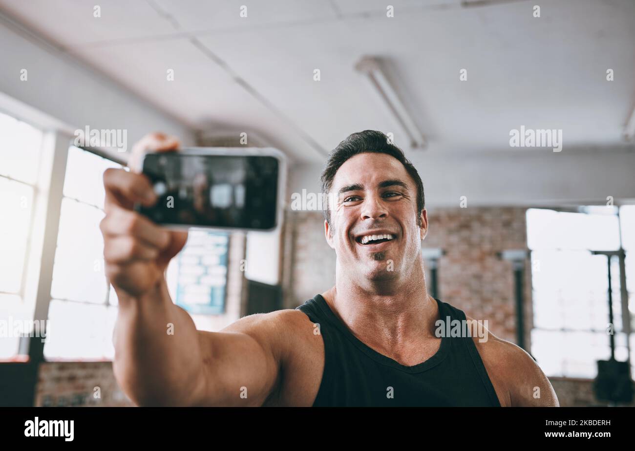 Ein junger Mann, der ein Selfie im Fitnessstudio gemacht hat. Stockfoto