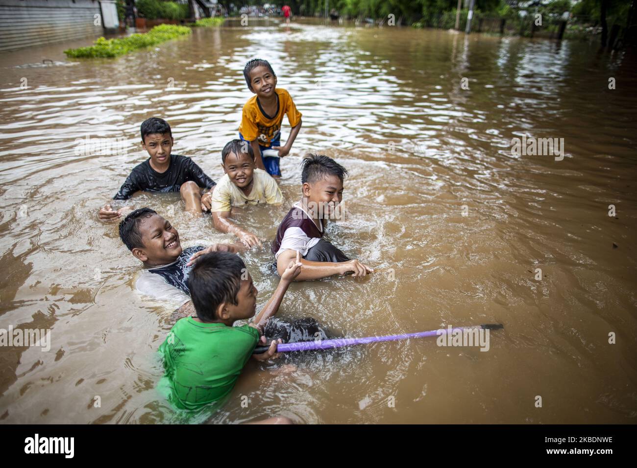 Jakarta, Indonesien, 02. Januar 2019 : Kinder posieren für Bilder, während sie in den Fluten spielen. Am zweiten Tag nach heftigen Regenfällen in Jakarta und Umgebung überschwemmten Überschwemmungen immer noch mehrere Gebiete, insgesamt starben 19 Menschen an der Flut. (Foto von Donal Husni/NurPhoto) Stockfoto