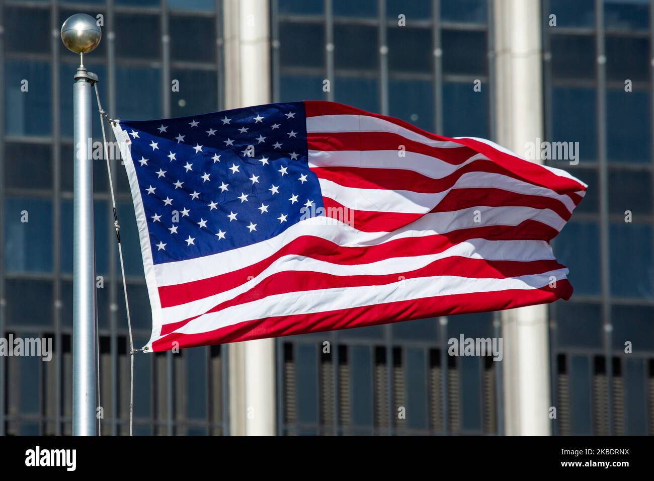 Die Nationalflagge der Vereinigten Staaten von Amerika, die am 13. November 2019 in der Innenstadt von Lower Manhattan, New York, an einem sonnigen Tag im Wind mit einem Wolkenkratzer im Hintergrund winkt. (Foto von Nicolas Economou/NurPhoto) Stockfoto