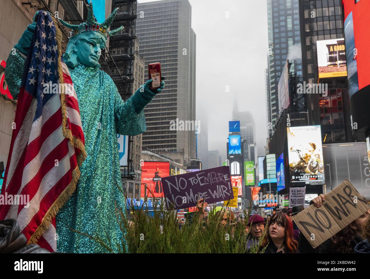 Ein Darsteller, der als „Lady Liberty“ gekleidet ist, nimmt Demonstranten während der Anti-Krieg-Iran-Kundgebung am Times Square am 4. Januar 2020 in New York, NY, auf Video auf. Qassem Soleimani, der Chef der iranischen Streitkräfte, wurde am Freitag bei einem US-Luftangriff in Bagdad getötet. (Foto von Erin Lefevre/NurPhoto) Stockfoto Ein Darsteller, der als „Lady Liberty“ gekleidet ist, nimmt Demonstranten während der Anti-Krieg-Iran-Kundgebung am Times Square am 4. Januar 2020 in New York, NY, auf Video auf. Qassem Soleimani, der Chef der iranischen Streitkräfte, wurde am Freitag bei einem US-Luftangriff in Bagdad getötet. (Foto von Erin Lefevre/NurPhoto) Stockfoto