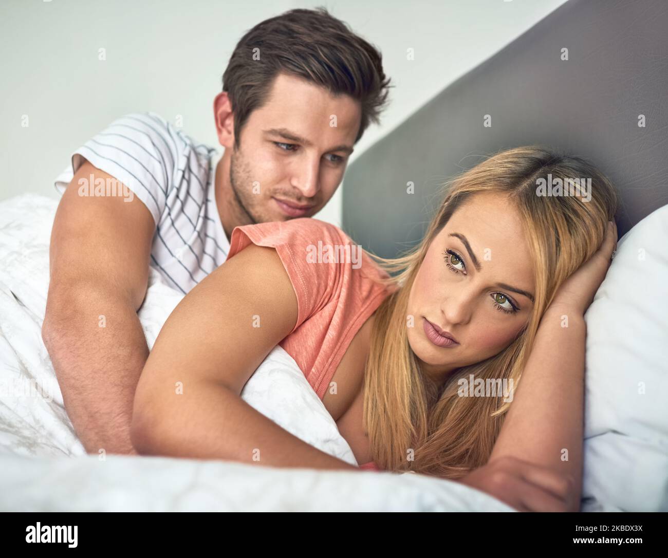 Ich bin nicht in der Stimmung. Eine junge Frau ignoriert ihren Mann, während sie im Bett liegt. Stockfoto