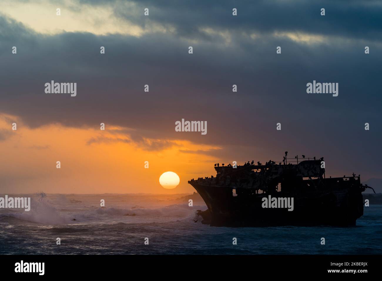 Die Sonne untergeht unter einem dramatischen Himmel am Wrack des Meisho Maru No. 38 an der wunderschönen Küste von Cape Agulhas in der Nähe der Küstenstadt L'Agulhas Stockfoto