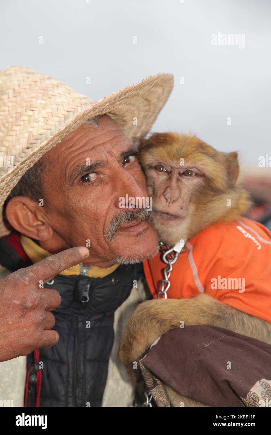 Am 5. Januar 2016 unterhält ein Mann mit einem Affen eine kleine Menschenmenge auf dem Platz Jemaa el-Fnaa in der Medina (Altstadt) von Marrakesch (Marrakesch) in Marokko, Afrika. Marrakesch ist die viertgrößte Stadt im Königreich Marokko. (Foto von Creative Touch Imaging Ltd./NurPhoto) Stockfoto