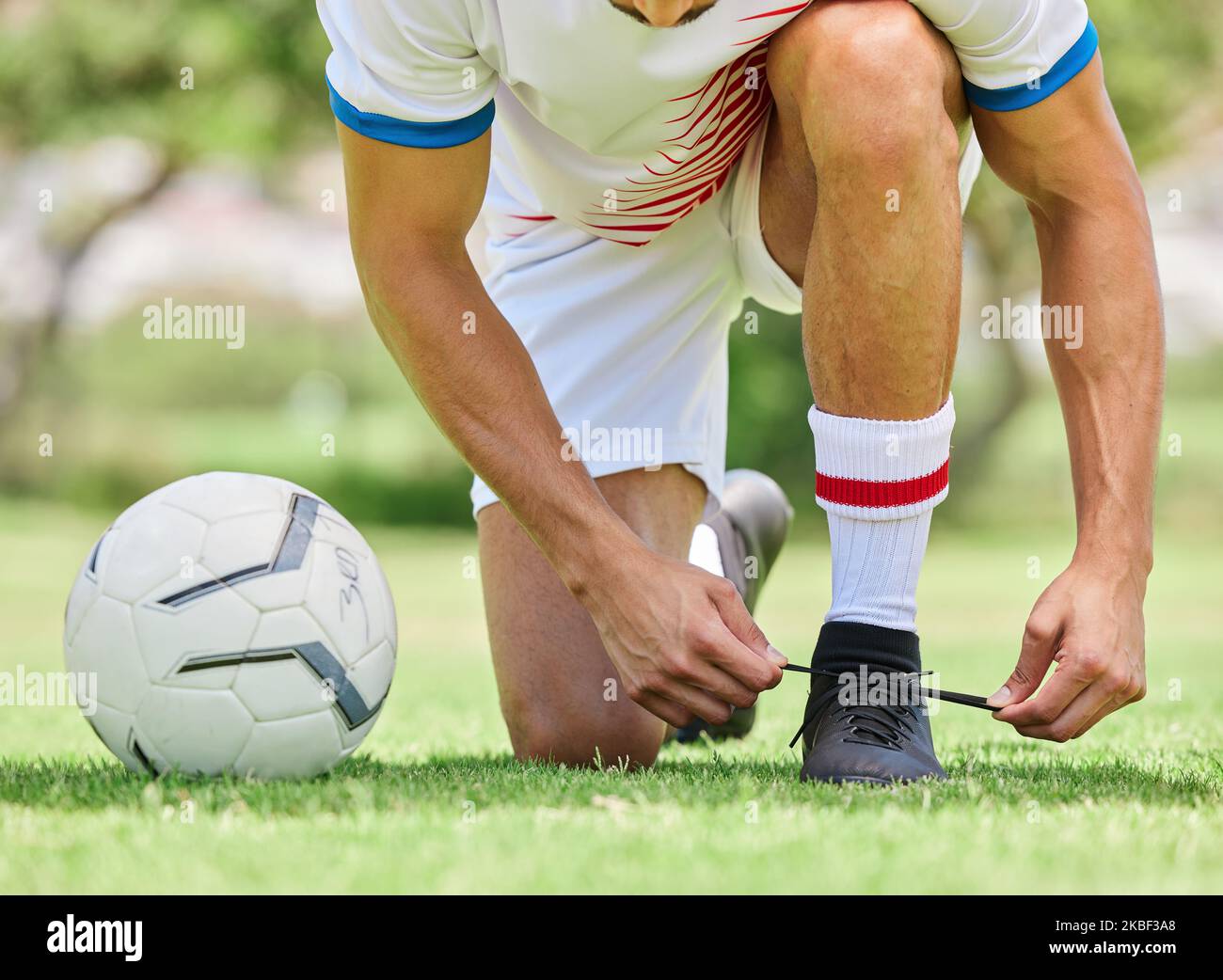 Sport-, Fußball- und Männer-Krawattenschuh auf dem Spielfeld, bereit für Spiel, Spiel und Outdoor-Training. Fitness-, Bewegungs- und Fußballspieler binden Schuhe auf Sneaker Stockfoto