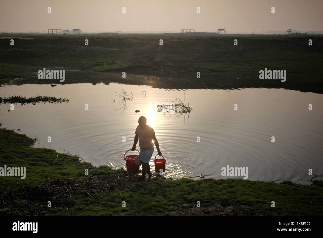 Masum Sarker (26) sammelt Wasser aus einem Teich, um sein Gemüsefeld in Rupganj , Narayanganj , Bangladesch am 22. Januar 2020 zu bewässern. (Foto von Syed Mahamudur Rahman/NurPhoto) Stockfoto