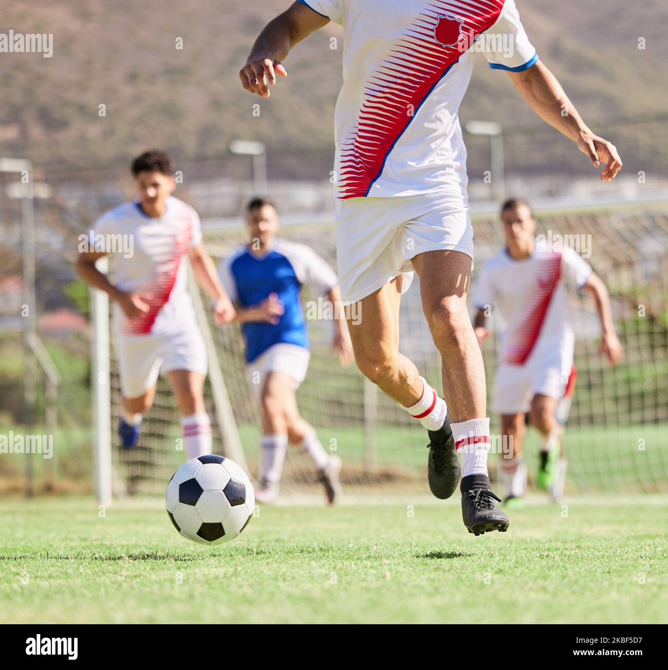 Fußball, Team und Laufen im Sportspiel, Fitness oder Sport mit dem Ball auf dem Feld im Freien. Gruppe von Fußballspielern auf den Angriff für Stockfoto