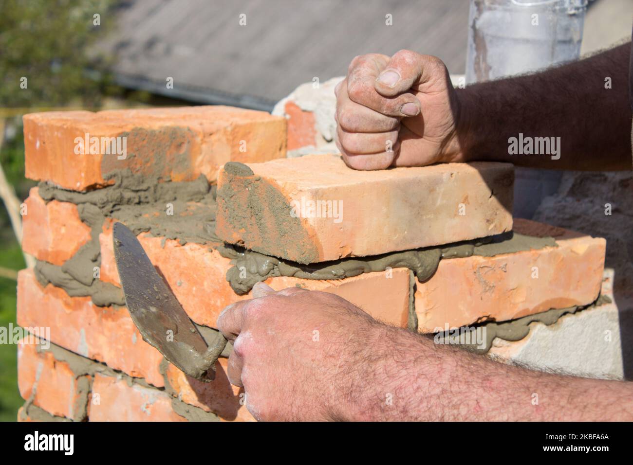 baumeister Gebäude aus rotem Ziegelkamin auf dem Dach Stockfoto