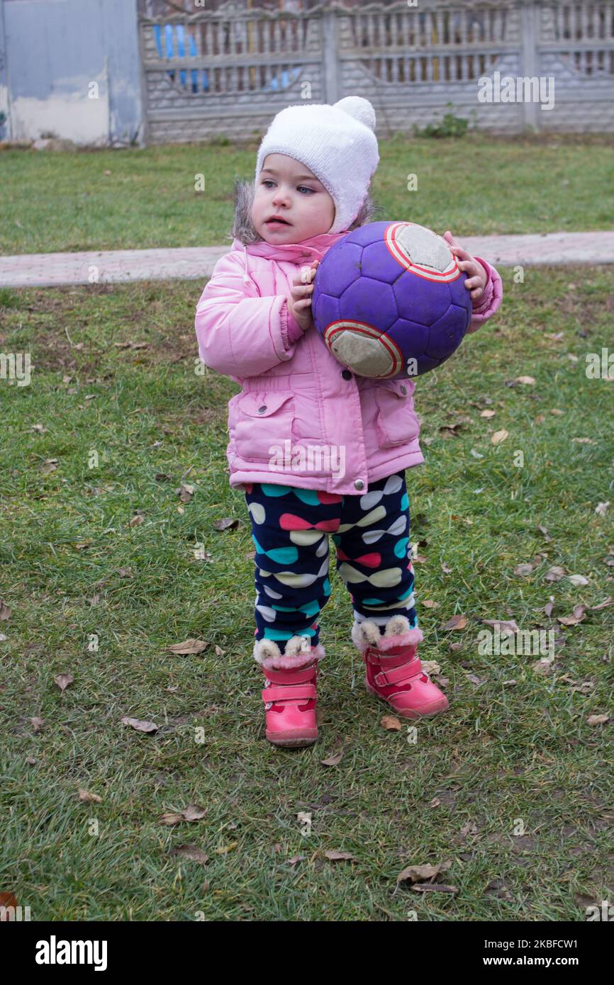 Autumn ist ein kleines Mädchen mit einem Ball in den Händen Stockfoto