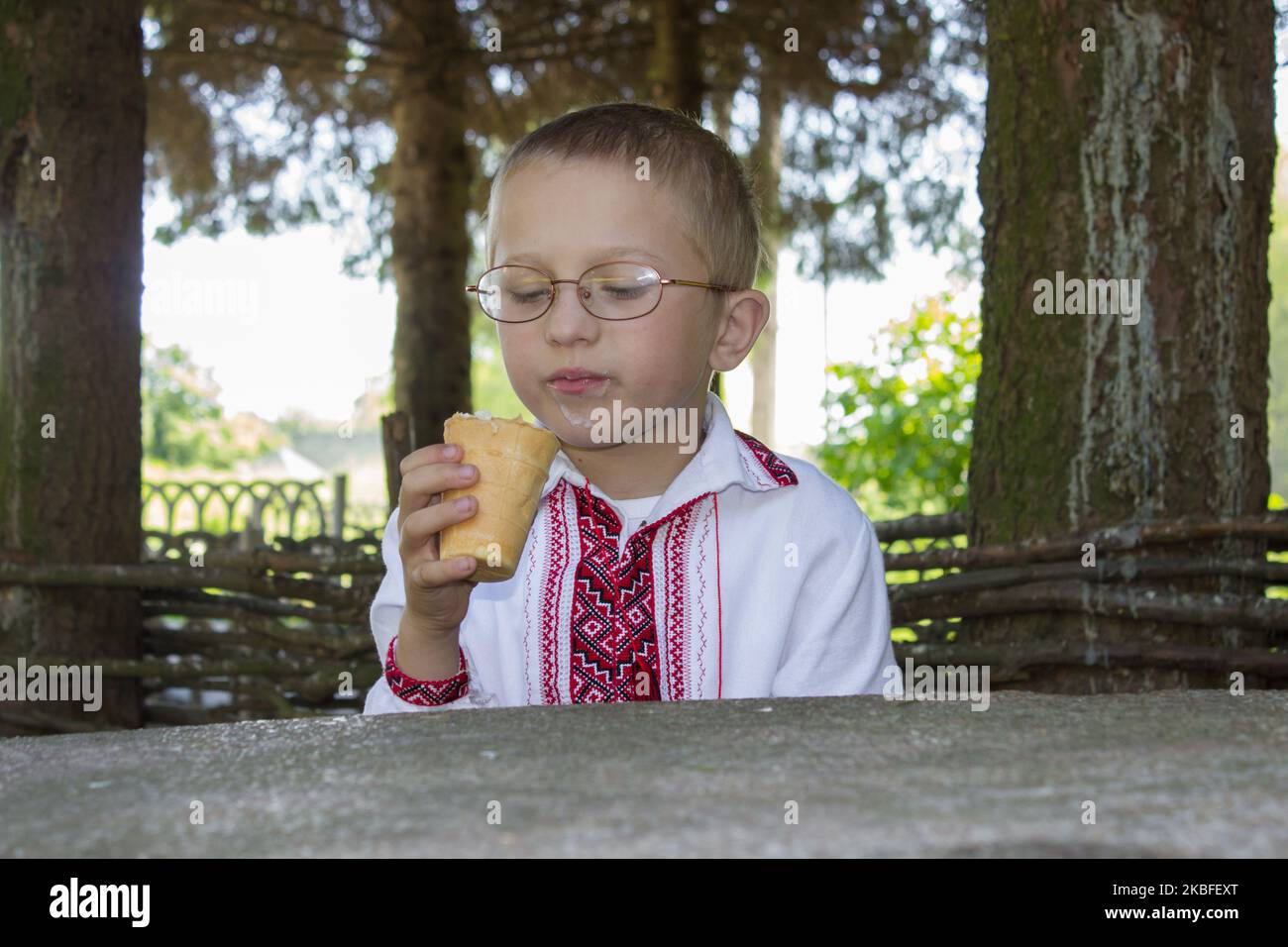 Boy sitzt und schaut auf ein Eis Stockfoto