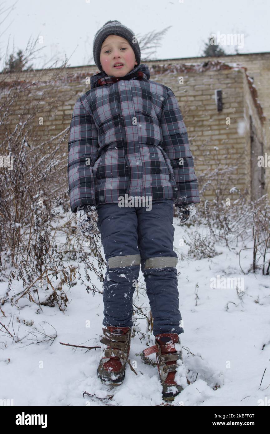 Der Junge stand im Winter auf einem Hügel und sah ängstlich aus Stockfoto