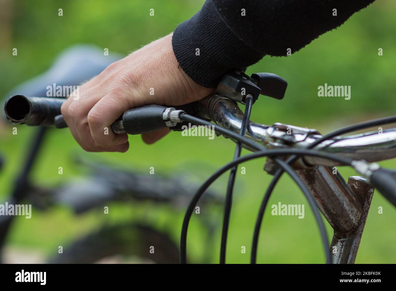 Die Hände des Mannes halten den Griff eines Zyklus Stockfoto