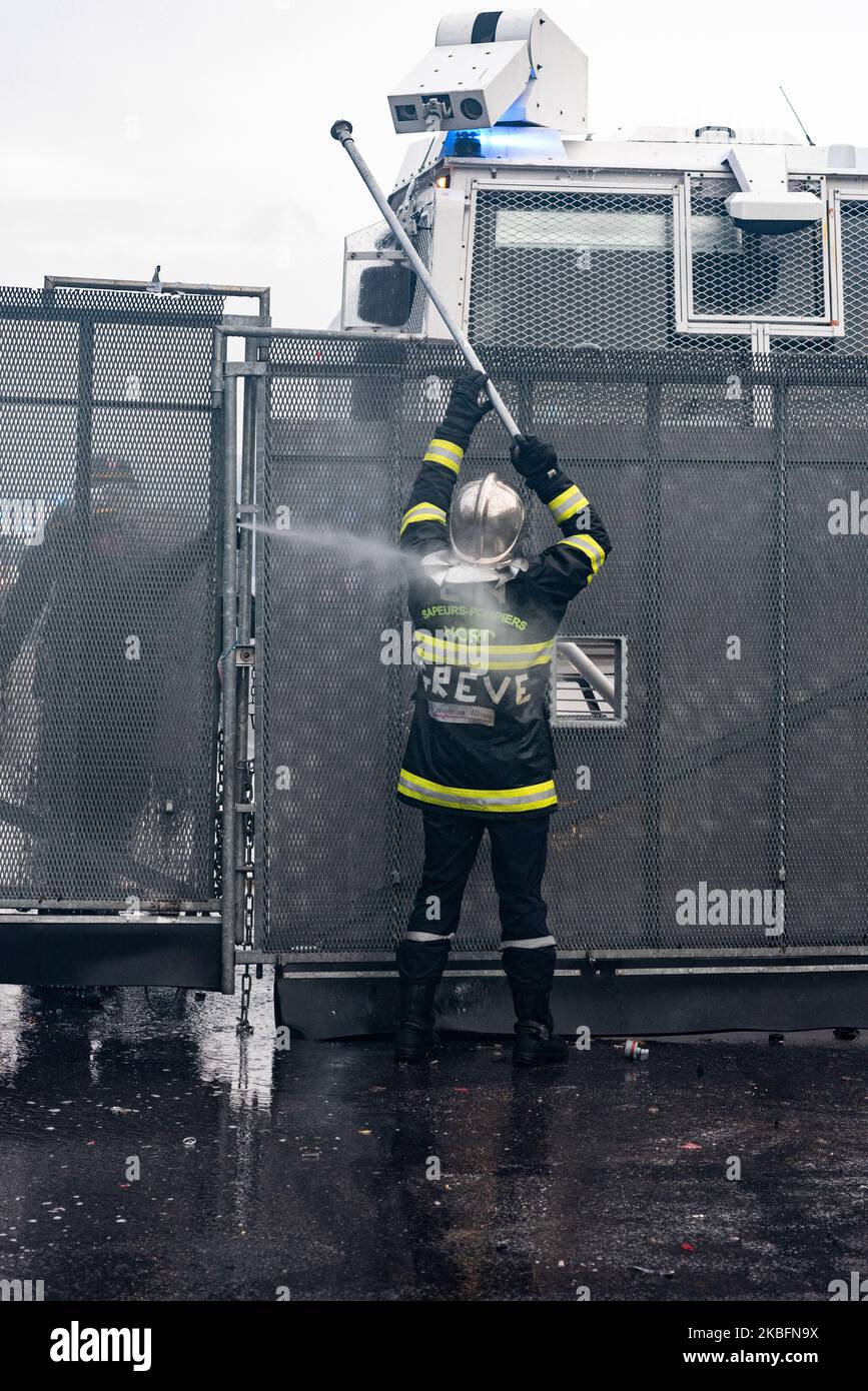 Ein Feuerwehrmann versucht am Dienstag, den 28. Januar 2020, auf Aufruf der Berufsfeuerwehrgewerkschaften, die Wasserwerfer-Kamera mit einem Eisenstab zu brechen. Mehrere tausend Feuerwehrleute demonstrierten in Paris zwischen dem Place de la République und dem Place de la Nation, um die Aufwertung des Feuerprämie und ihren Ruhestand zu fordern. Auf dem Weg der Prozession kam es zu Zusammenstößen mit der Polizei, und am Ende der Demonstration, bei der einige hundert Menschen versuchten, eine Brückenstange zu brechen, setzte die Bereitschaftspolizei Wasserwerfer und Tränengasgranaten sowie die neuen GM2L Granaten ein, um sie abzuwehren. (Foto Stockfoto