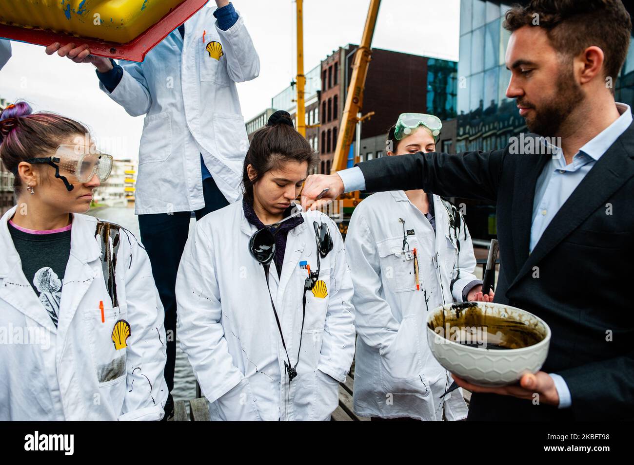 Ein Aktivist wirft gefälschtes Öl über andere Aktivisten, während einer Aufführung von Shell muss fallen an der Universität von Amsterdam, am 30.. Januar 2020. (Foto von Romy Arroyo Fernandez/NurPhoto) Stockfoto