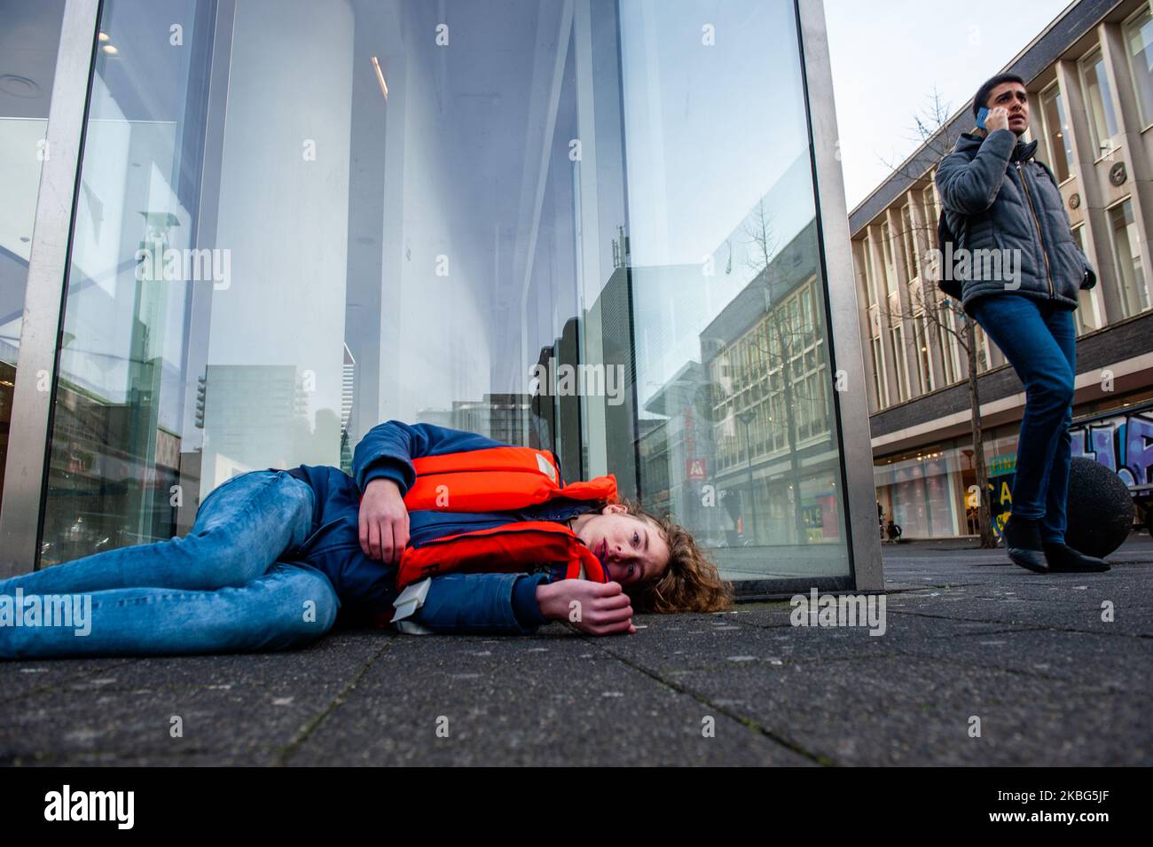 Ein XR-Aktivist täuscht vor, ein falscher Tod zu sein, während ein Mann am 3.. Februar 2020 in Rotterdam beim dritten Extinction Rebellion die in Aktion in Aktion ist, indem er mit seinem Telefon spricht. (Foto von Romy Arroyo Fernandez/NurPhoto) Stockfoto