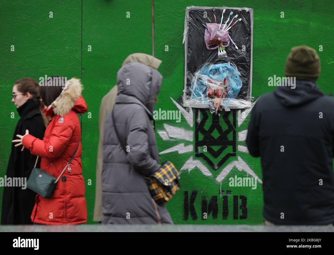 Die Menschen achten auf das Kunstobjekt der PlasticWood-Gruppe, wenn sie am Bauzaun in Kiew, Ukraine, am 4. Februar 2020 vorbeigehen. Die ukrainische Öko-Kunstgruppe PlasticWood kreiert die Kunstobjekte aus den Abfällen und hängt sie in der Innenstadt von Kiew auf. (Foto von Sergii Chartschenko/NurPhoto) Stockfoto
