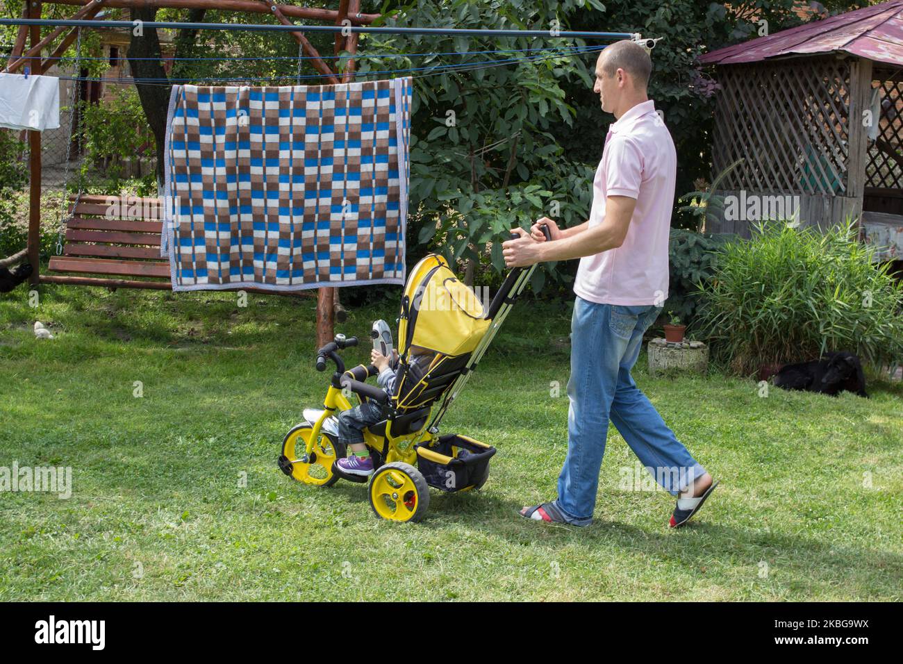 Vater transportierte ein Kind auf einem Dreirad Stockfoto