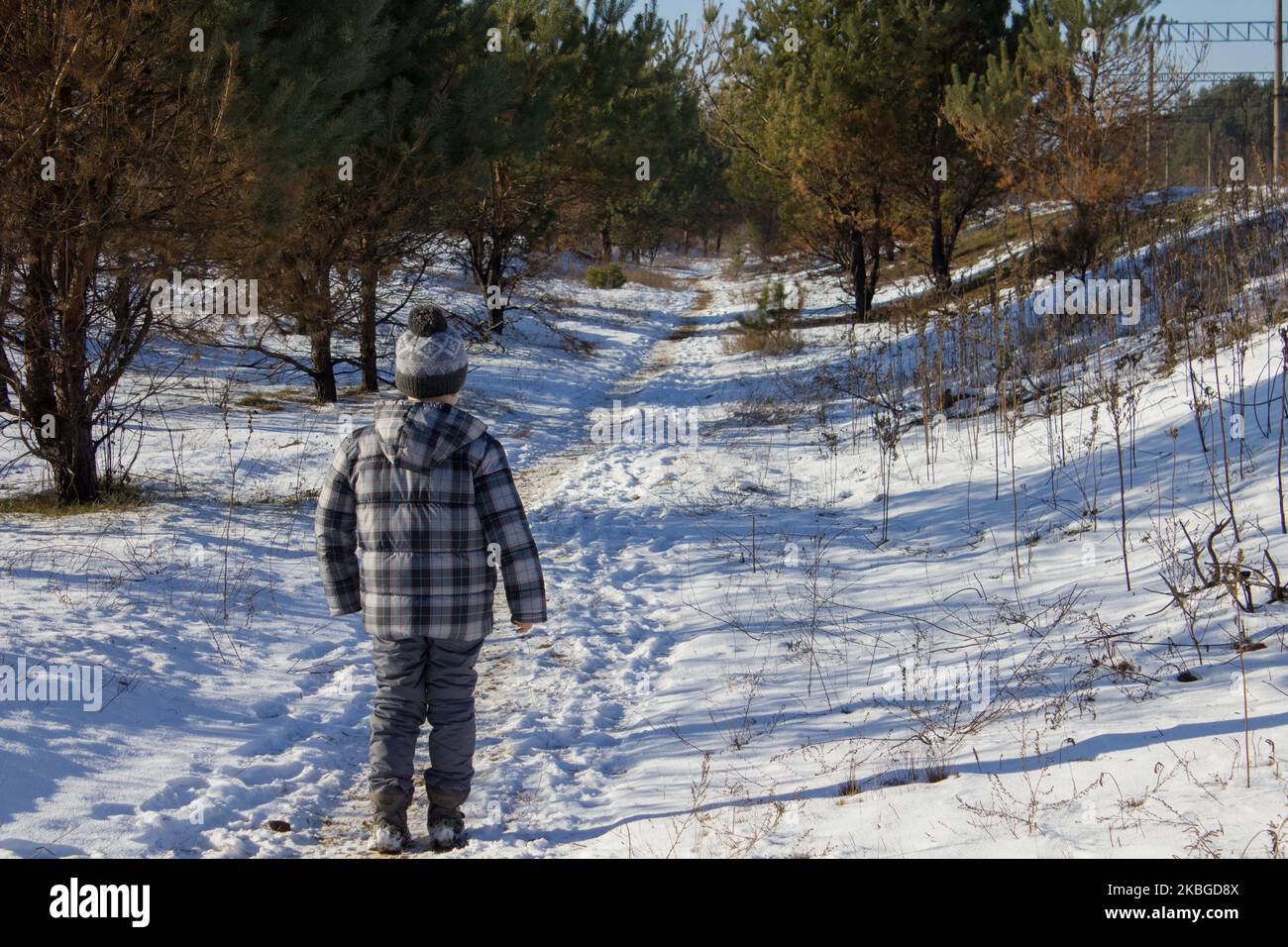 Winter kleiner Junge geht in den Wald für den Weihnachtsbaum Stockfoto