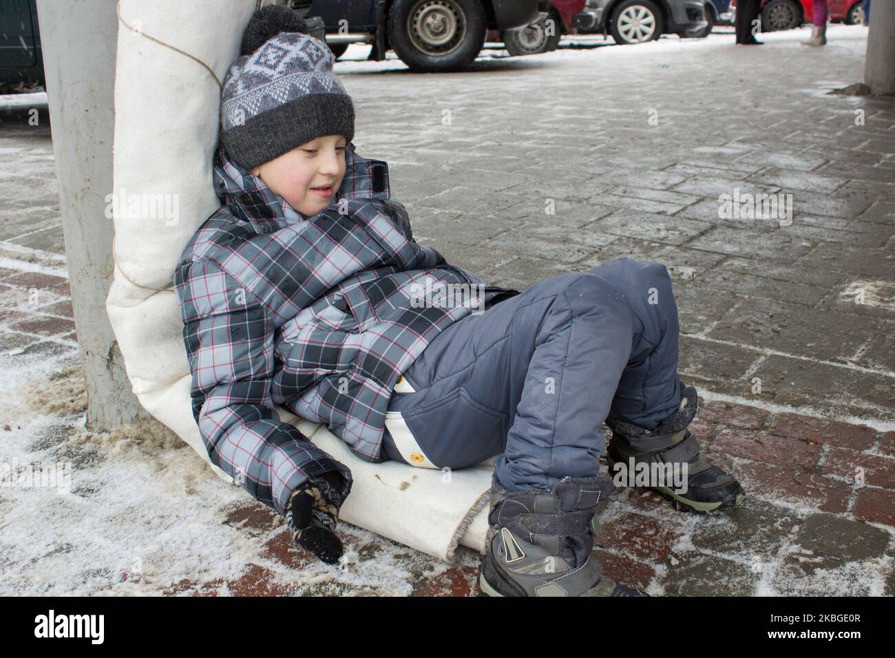 Junge liegt auf dem Bürgersteig im Winter die Straßen Stockfoto